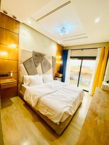 a bedroom with a bed and a large window at New dream home in Fez