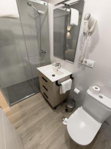 a bathroom with a shower and a toilet and a sink at Hostal El Cruce in Paracuellos de Jarama