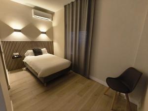 a small bedroom with a bed and a chair at Hostal El Cruce in Paracuellos de Jarama
