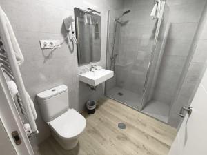 a bathroom with a shower and a toilet and a sink at Hostal El Cruce in Paracuellos de Jarama