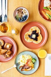 a table with plates of breakfast food on it at The Social Hub Delft in Delft