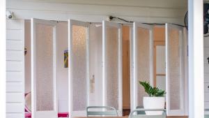 a row of mirrors with chairs and a potted plant at White Cockatoo Beachfront Cottage in Newell Beach