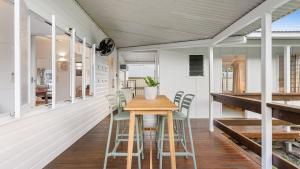 a dining room with a wooden table and chairs at White Cockatoo Beachfront Cottage in Newell Beach