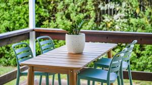a wooden table with chairs and a potted plant at White Cockatoo Beachfront Cottage in Newell Beach +38 photos