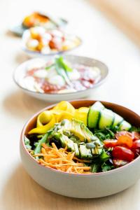 a bowl of salad on a table with other plates of food at The Social Hub Delft in Delft