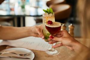 two people are holding a drink on a table at The Social Hub Rotterdam in Rotterdam +33 photos