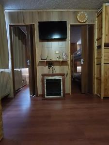 a living room with a fireplace and a flat screen tv at Marilleva 1400 - Alpine Apartment in Marilleva