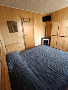 a bedroom with a bed and wooden walls at Marilleva 1400 - Alpine Apartment in Marilleva