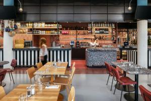 a restaurant with wooden tables and chairs and a bar at The Social Hub Delft in Delft