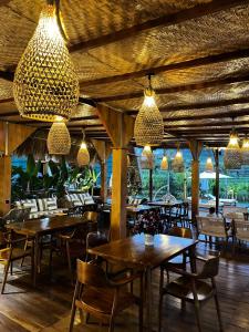 a restaurant with wooden tables and chairs and lights at Cascadia Rad Villa in Jatiluwih
