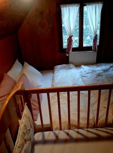 a bed with white sheets and pillows in a bedroom at Planinska kucica Srce in Zlatibor