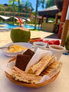 a plate of sandwiches and other food on a table at Chalé Mar e Sol, Marina e Resort Angra in Angra dos Reis