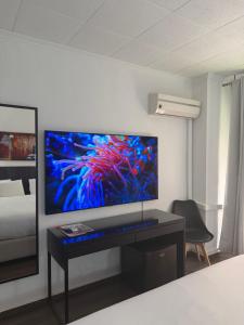 a room with a large screen tv on a wall at Hotel Carlos III in Águilas