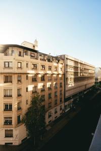 an apartment building with the sun shining on it at LOFT Hotel by Sommelier Hoteles in Santiago