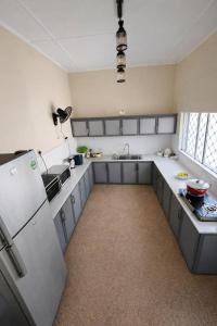 a large kitchen with a refrigerator and a sink at The Deane Residence Double Room in Colombo +7 photos