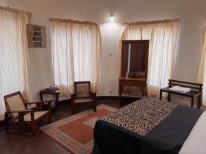 a bedroom with a bed and a table and chairs at The Deane Residence Double Room in Colombo