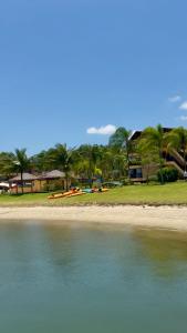 a beach with a group of boats in the water at Chalé Mar e Sol, Marina e Resort Angra in Angra dos Reis