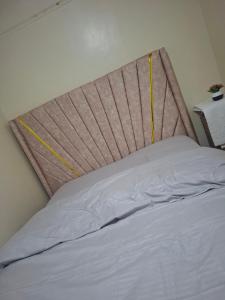 a bed with a headboard in a bedroom at Larmar Homes- Kajiado in Kajiado