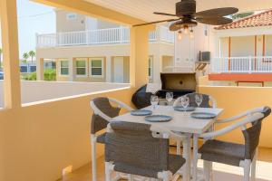 a dining room with a table with chairs and a ceiling fan at Pompano Beachview Home home in South Padre Island