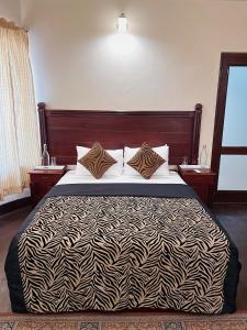 a bedroom with a bed with a black and white comforter at The Deane Residence Double Room in Colombo