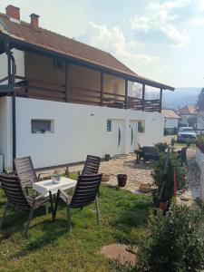 a house with two chairs and a table in the yard at Apartmani Lukic 2 in Banja Koviljača