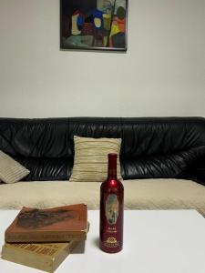 a bottle of wine sitting on a table next to a couch at Central apartment 3 in Gnjilane +6 photos
