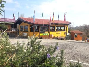 a yellow bus with flags on top of it at Garden Village San Marino in San Marino +49 photos