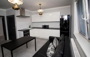a living room with a couch and a kitchen at Mia Mia House in Katowice