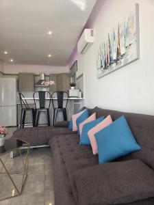 a living room with a brown couch with blue pillows at 2 bedroom home sea view in Pyla