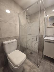 a bathroom with a toilet and a glass shower at 2 bedroom home sea view in Pyla +14 photos