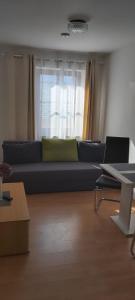 a living room with a blue couch and a window at Pension Post - Sistrans in Innsbruck