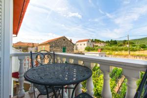 a table and chairs on a balcony with a view at Apartments Miljenko in Dobropoljana