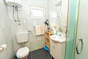 a bathroom with a toilet and a sink at Apartments Miljenko in Dobropoljana +25 photos
