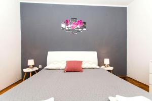 a bedroom with a large white bed with two lamps at Apartments Miljenko in Dobropoljana