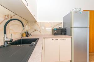 a kitchen with a sink and a refrigerator at Apartments Miljenko in Dobropoljana