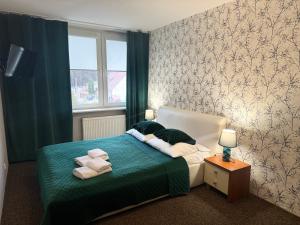 a bedroom with a bed with towels on it at Sosnowe Zacisze in Białystok