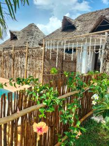 a house with a fence and flowers in front of it at Sunset Lover in Michamvi