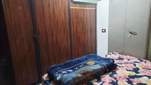 a bed with a blue blanket on top of it at Radha Rani Guest House in Sīkar