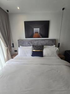 a bedroom with a large white bed with white pillows at Belrose Place in Accra +11 photos