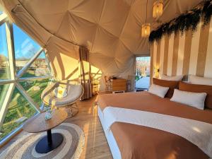 a bedroom with a bed and a large window at Dôme Saint-Eloi in Floursies