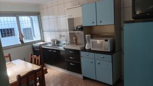 a kitchen with a microwave and a table in it at Casa simples e arejada in Caxias do Sul