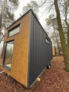 a tiny house on wheels in the woods at Pomiedzy debami - domki in Emilia