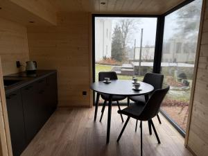 a kitchen with a table and chairs and a window at Pomiedzy debami - domki in Emilia