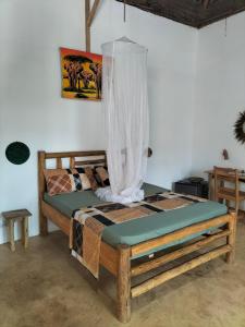 a bedroom with a wooden bed with a canopy at Sunset Lover in Michamvi