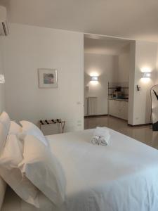 a bedroom with a large white bed with two towels on it at CconfortHotels Sea Dream Palace in Trani