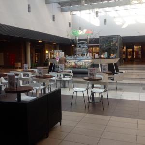 a restaurant with tables and chairs in a mall at Apartament Nad Galerią in Stargard
