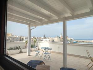 a balcony with chairs and a table on a roof at CconfortHotels Sea Dream Palace in Trani