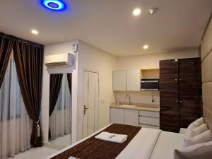 a small room with a bed and a kitchen at Presken Apartment Ikoyi in Lagos