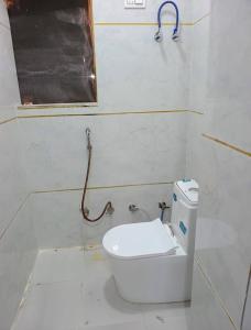 a bathroom with a toilet and a pipe on the wall at Hotel Suraj Palace And Restaurant in Rūpaheli