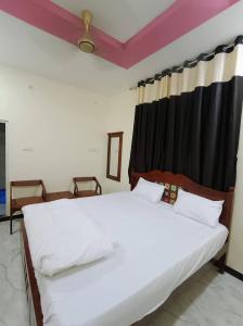 a bedroom with a large bed with white sheets at Hotel Suraj Palace And Restaurant in Rūpaheli